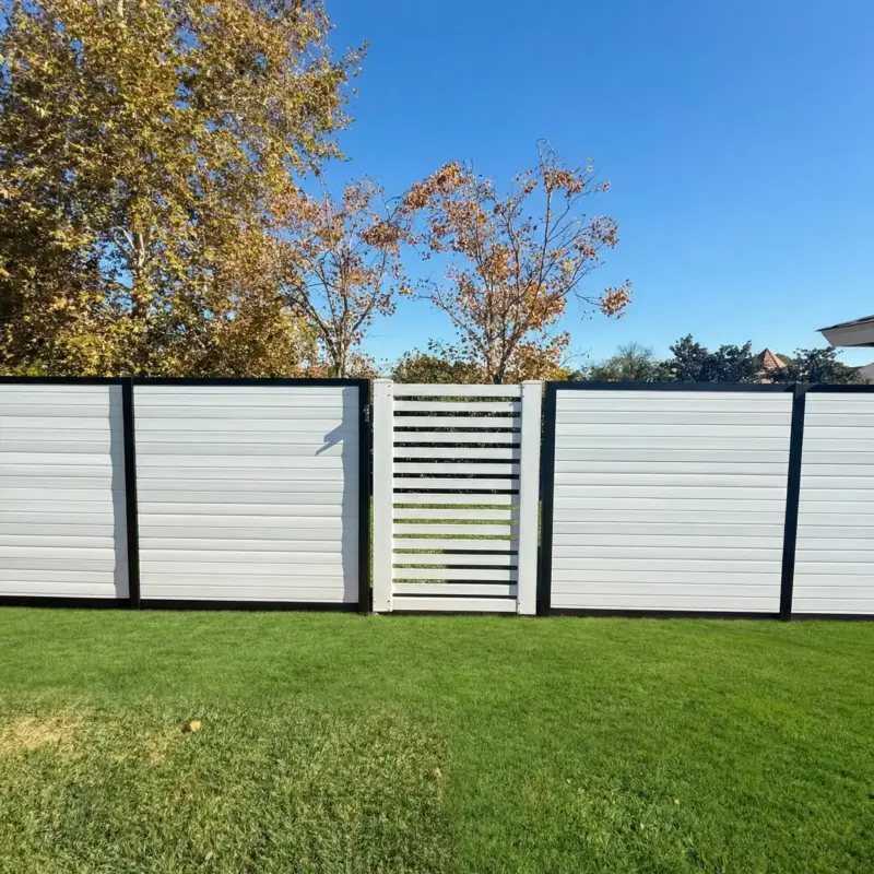 A Section Of Contemporary White Vinyl Fencing With Black Trim, Including A Gate With Open Horizontal Slats That Allows A View Through