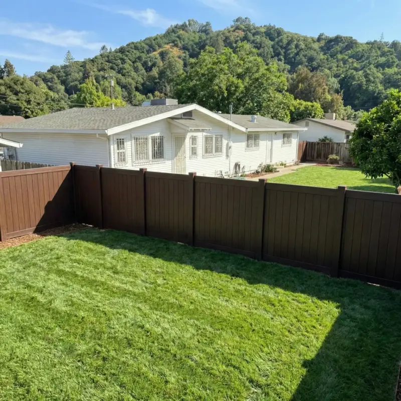 Aerial View Of A Residential Backyard Showing The Layout Of A Brown Perimeter Fence Enclosing A Manicured Lawn