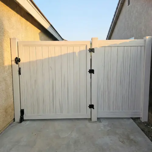 Composite Privacy Gate In A DoubleDoor Style, Featuring A Vertical Board Design, Black Hinges, And A Latch, Installed At A Residential Entrance