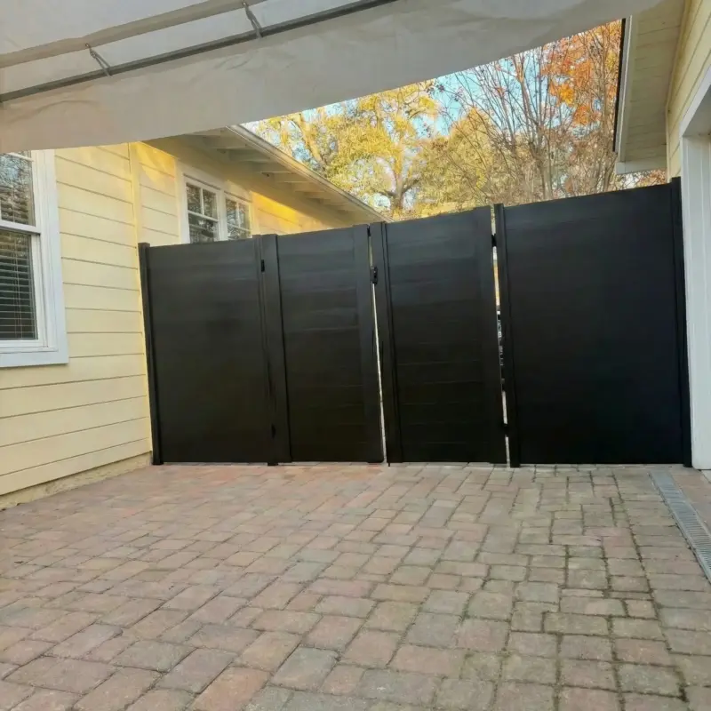 Dark Horizontal Privacy Fence And Gate Section Under An Awning, Showing Sunlight Filtering Through Autumn Trees In The Background