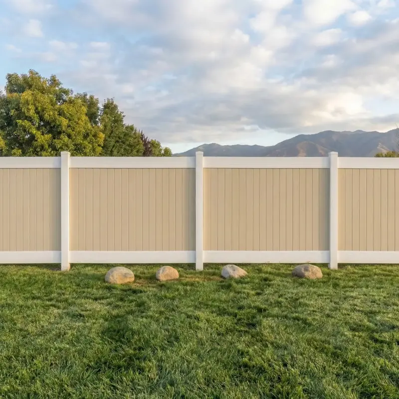 LowMaintenance Beige And White Vinyl Fence Providing Privacy For A Large Grassy Yard Under A Cloudy Sky